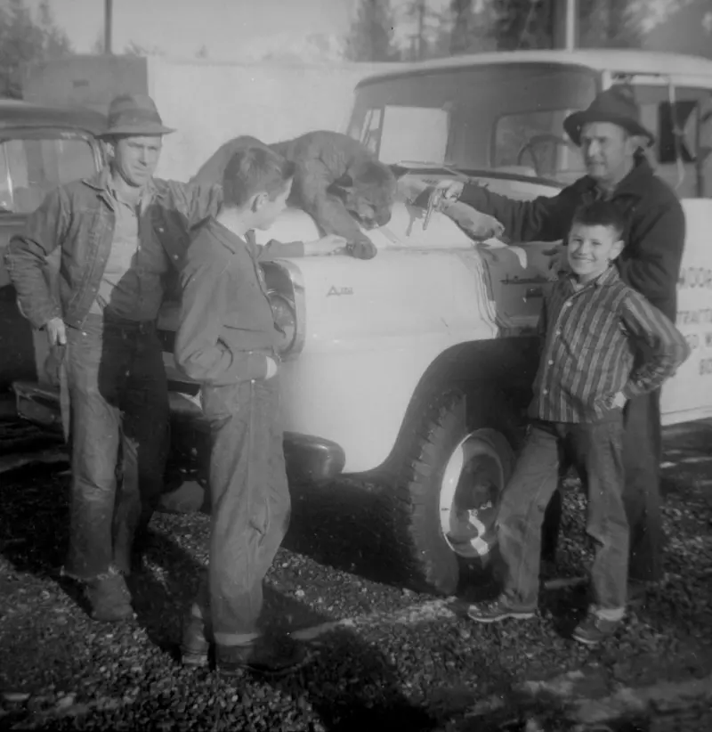Men and kids pose with a cougar 