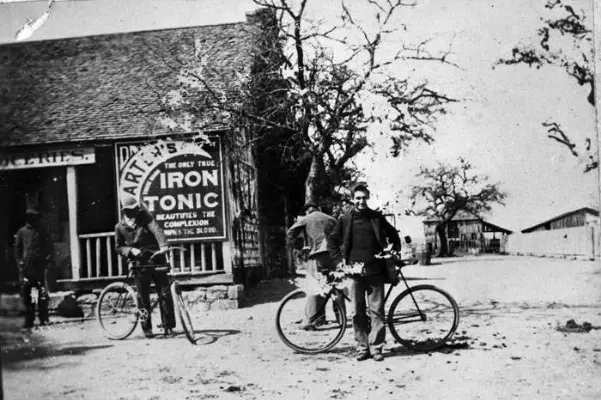 bicycle riders in front of a small neighborhood grocery store