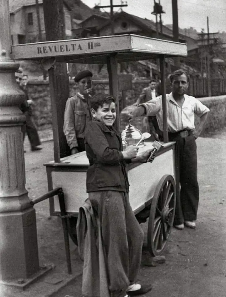 Muchacho apoyado en un carrito de helados