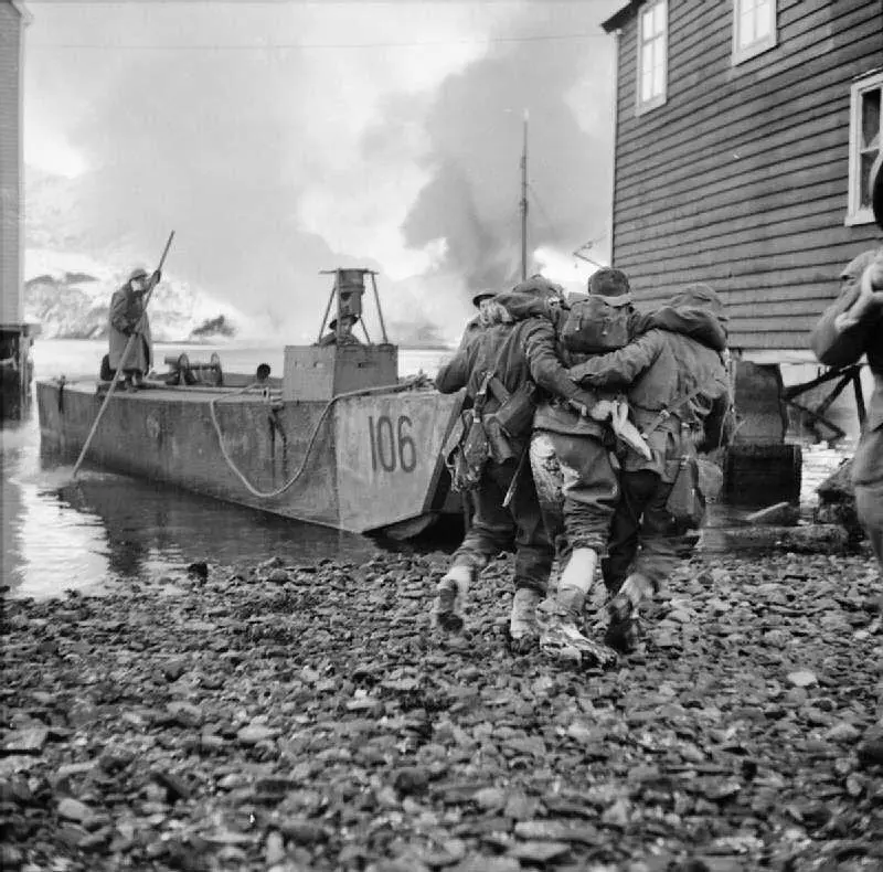 British Commandos help a wounded comrade back to the LCA (