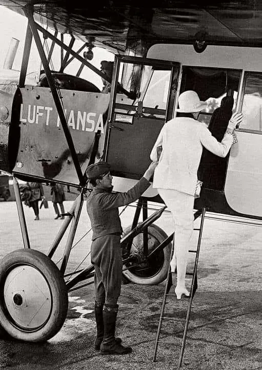 Steward assisting a lady in Fokker-Grulich F.II aircraft