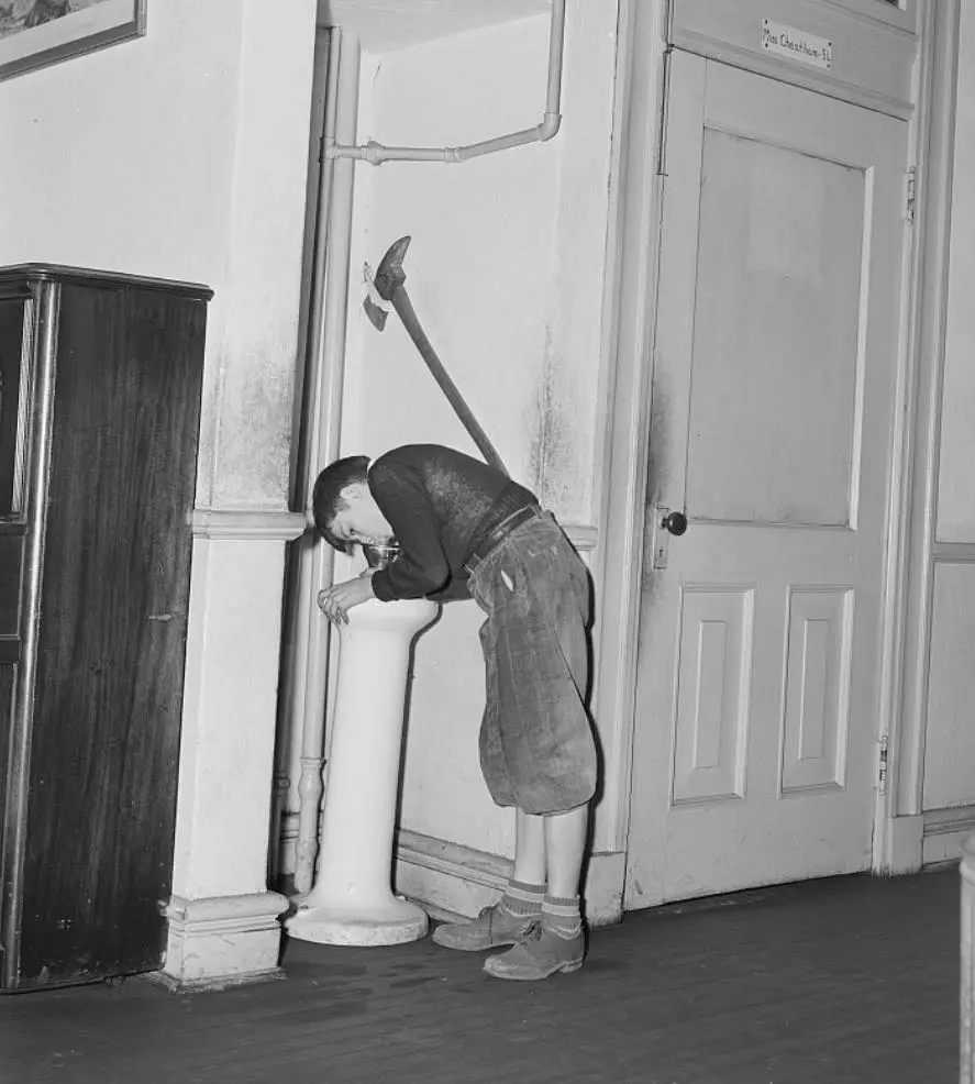 A schoolboy drinking water 