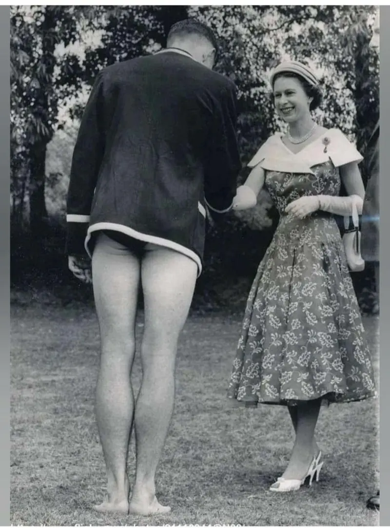 Elizabeth II shakes hands with the captain of the swimming team D. G. Owen